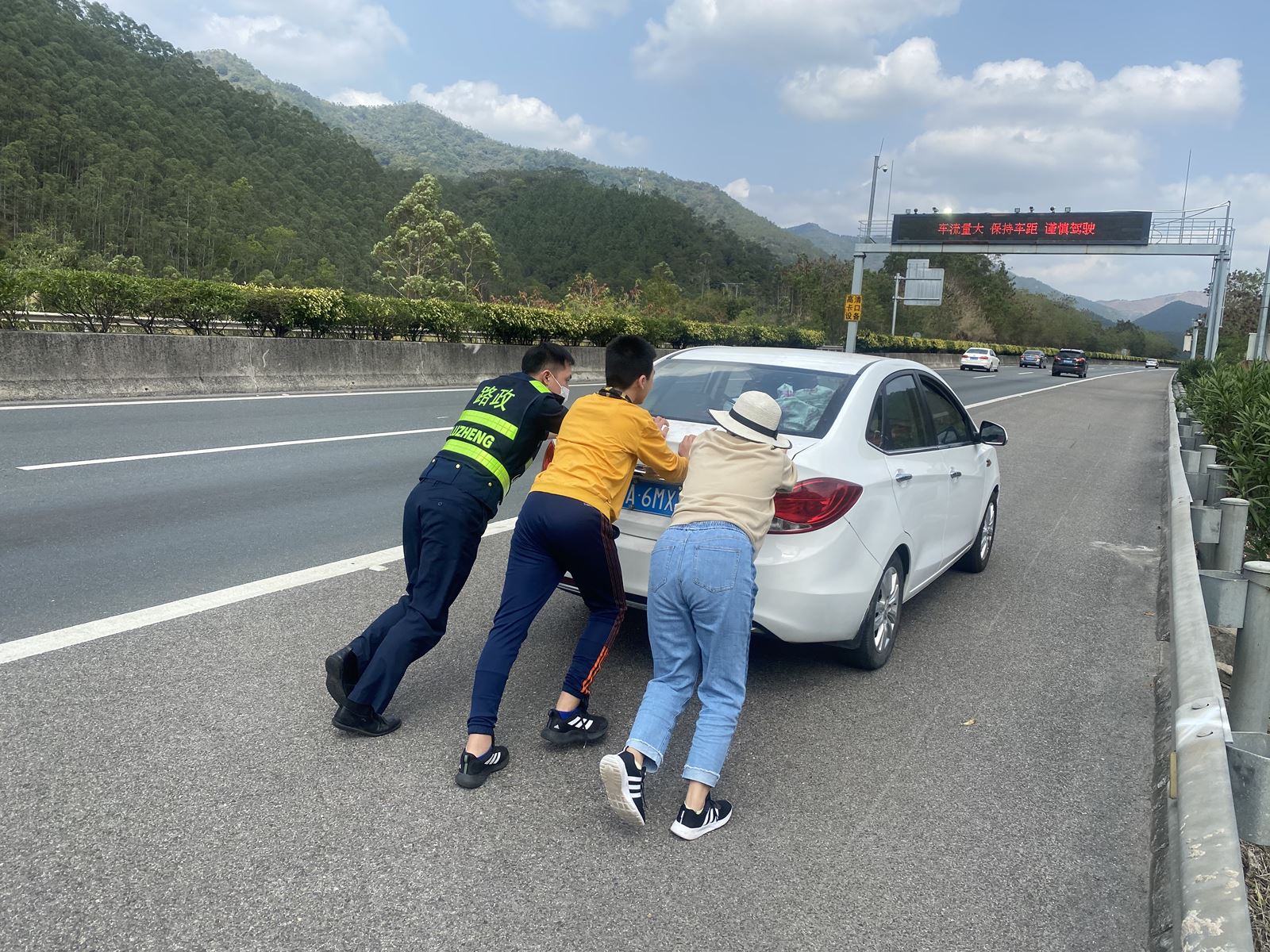 汽车高速路上抛锚 路政员合力推车解困